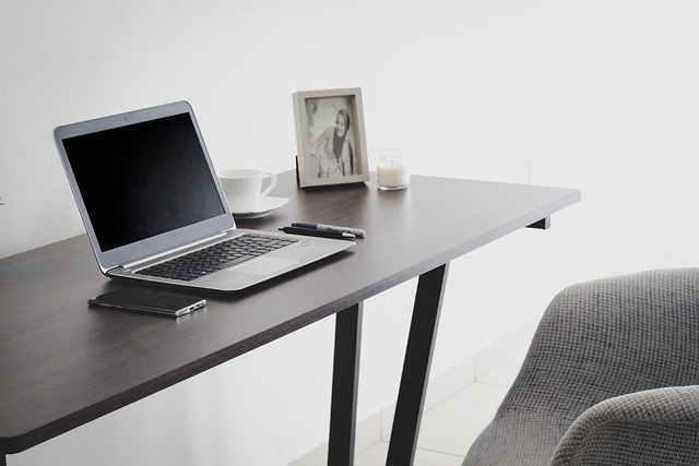 electronics training materials on laptop with notes and smart home devices on desk